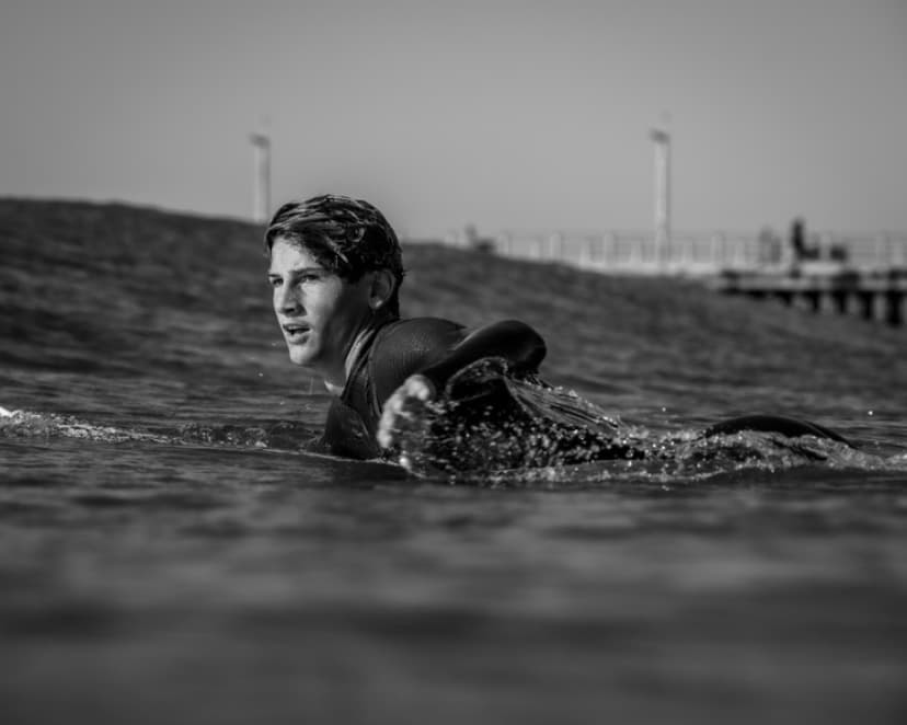 Nate Colby paddling out in black and white